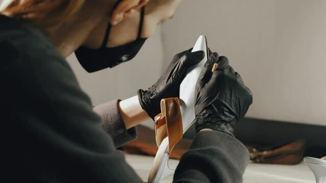 Shoe restorer. Shoe repair. Applying glue with a brush to the fastening of the sole and the toe of the shoe