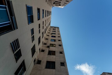 Low-angle of exterior view of a tall, multi-story building with a blue sky in the background