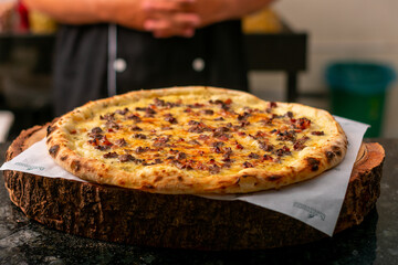 Brazilian pizza, bacon pizza with cheese, tomato sauce, cheese, rustic wooden background