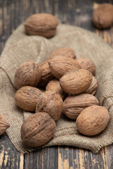 Whole walnuts on a wooden background, top view