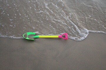 Colorful toy scoop on the sandy beach.