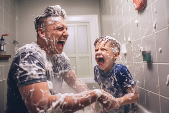 Grandfather and grandson having fun in the shower, splashing water.