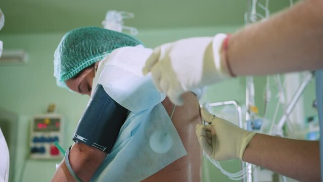 Male doctor injecting Epidural Anesthesia for pregnancy Labor during childbirth for women patient in hospital. Spinal anesthesia. Doctor makes a puncture in the lumbar spine. Preparation for surgery.