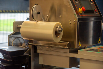 Industrial machinery designed for packaging products using rolls of film.