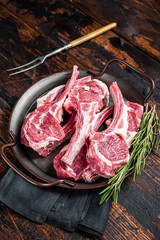 Raw lamb mutton chop steaks, fresh meat cutlets on butcher table. Black background. Top view