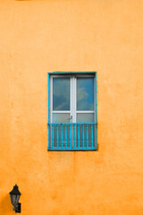 beautiful antique blue wooden window on wall of colorful colonial house in the city of cartagena de indias