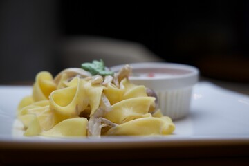 White ceramic plate with a portion of steaming creamy pasta topped with mushroom