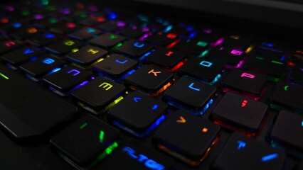 There are a few glowing keys on the keyboard of the laptop - obrazy, fototapety, plakaty