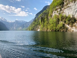 Tranquil Lake Konigssee surrounded by majestic mountain range on a sunny day