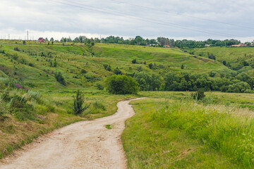 country road and a lot of green grass around