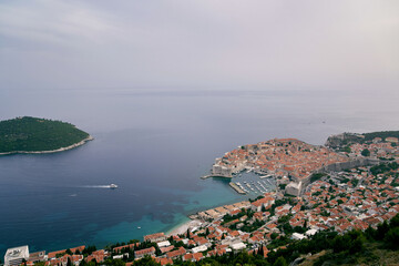 Fototapeta na wymiar View from the mountain to the yacht sailing on the sea to the port of Dubrovnik. Croatia