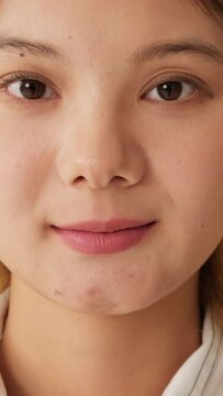 Close-up, young woman opening eyes and looking at camera isolated on yellow background in studio