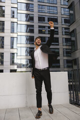 Stylish male manager with laptop standig on office terrace. High quality photo