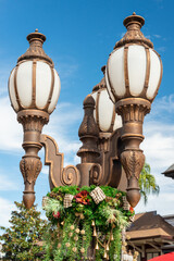 Three brass cast street lamps on a single decorative post of forged metal. The antique park light...