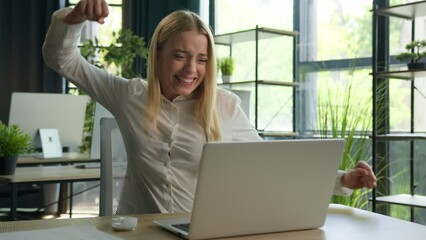 Excited happy Caucasian businesswoman woman female winner win online bet on laptop computer celebrate business success joyful girl in office winning job profit luck achievement scream euphoria victory