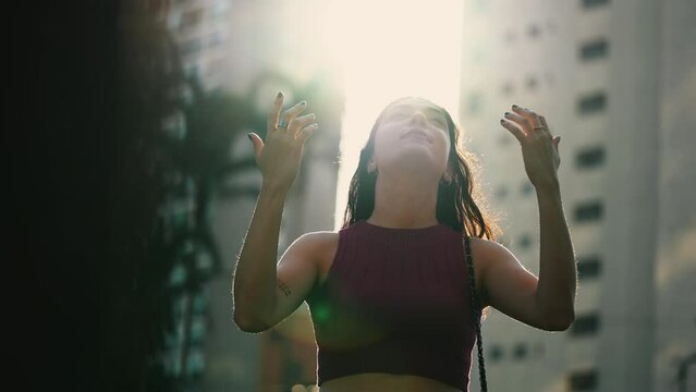 One young Religious woman looking up at the sky with HOPE and FAITH. A happy person feeling GRATEFUL putting hand in CHEST