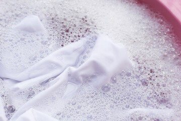 Laundry concept, white shirt soaking in water with detergent water dissolution, washing cloth - obrazy, fototapety, plakaty