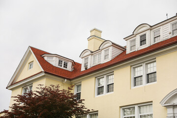 suburban house framed by a white picket fence, symbolizing the American dream, faces the skyward trend of mortgage inflation and rising property prices
