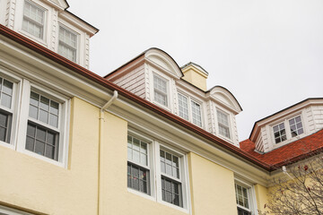 suburban house framed by a white picket fence, symbolizing the American dream, faces the skyward trend of mortgage inflation and rising property prices