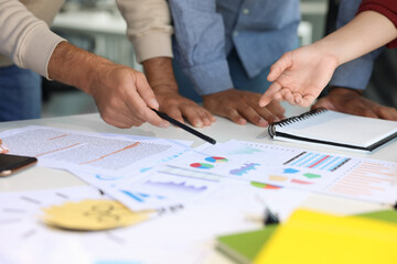 Team of employees working with charts at table, closeup. Startup project