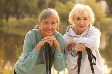 Two senior women with Nordic walking poles outdoors