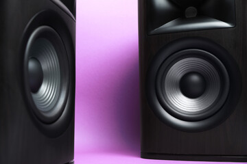 Wooden sound speakers on violet background, closeup