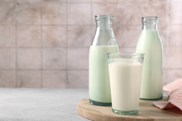 Glassware with tasty milk on light table, space for text