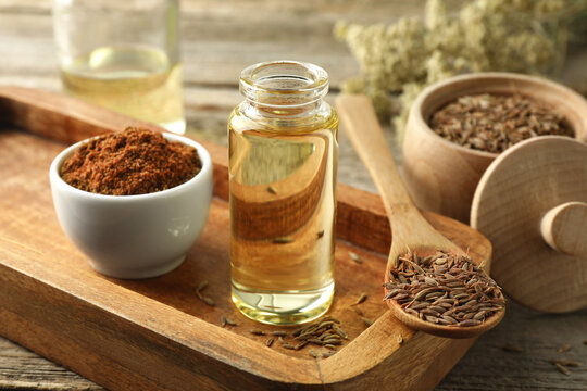 Caraway (Persian cumin) seeds, powder and essential oil on table, closeup