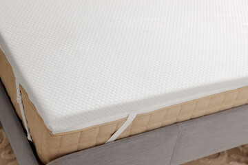 White memory foam mattress topper on grey bed