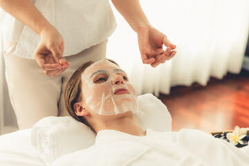 Obraz na płótnie Canvas Serene modern daylight ambiance of spa salon, woman customer indulges in rejuvenating with facial skincare mask. Facial skin treatment and beauty cosmetology procedure for face. Quiescent