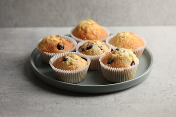 Delicious sweet muffins with berries on grey table