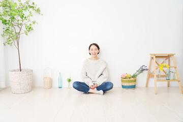 リビングに座る笑顔の女性のポートレート　全身　カメラ目線　コピースペースあり