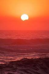Colourful orange sunlit sky with ocean waves. Gold Coast Australia