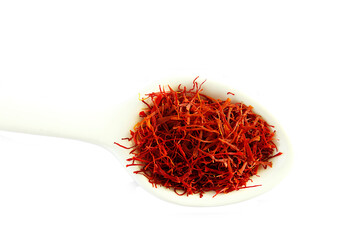 heap of organic dried saffron thread spice in spoon isolated,also known in india as kesar on cutout...