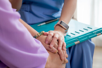 Closeup hands caregiver woman or doctor sitting on sofa encourage and care senior in living room at home, caretaker or nurse holding hands of patient elderly for encourage, medical and insurance.