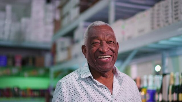 Portrait of a joyful Black Senior Brazilian man smiling at camera standing inside supermarket laughing