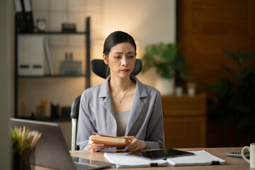 Asian businesswoman holding notebook about business, spending money