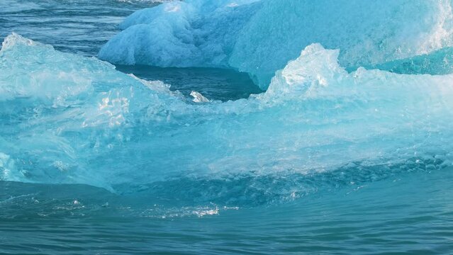 Blue Iceberg Drifts In Salty Sea Water, Jokulsarlon Glacier Lagoon In Iceland, Pure Blue Ice From Melting Glacier