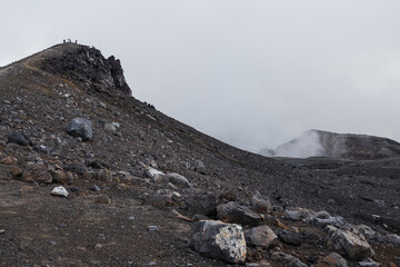 Severe mountain landscape. View of the top of the volcano. Rocks on the rim of a volcanic crater. Travel, tourism and hiking on the Kamchatka Peninsula. Gorely volcano, Kamchatka Territory, Russia.