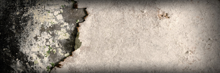 Torn old faded paper wallpaper on a concrete wall. Ragged scraps of white paper on a gray background. Vintage texture for background and design. Closeup view with copy space for text.