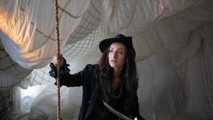 Pirate lady pulls a tightrope, beautiful young brunette in a pirate costume