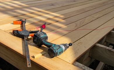 Old builders tools and red string on new wooden decking under construction