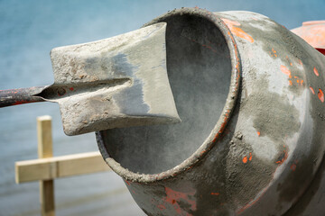 Focus on inside concrete mixer turning blurred in motion with shovel raised