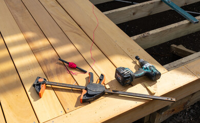 Old builders tools and red string on new wooden decking under construction