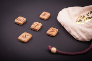 runes for predictions burned on wooden plates on a black background