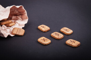 runes for predictions burned on wooden plates on a black background
