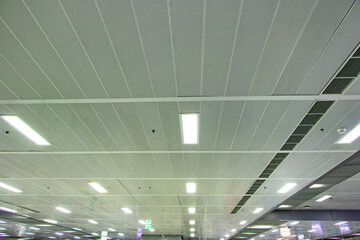 Ceiling with light bulbs lighting with ventilation pipes in train station in Thailand. Most popular...