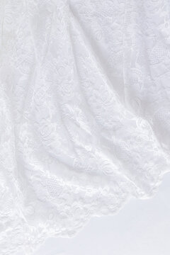 Soft airy pleats of lacy white fabric. part of the bride's wedding dress. Vertical abstract wedding background for design.