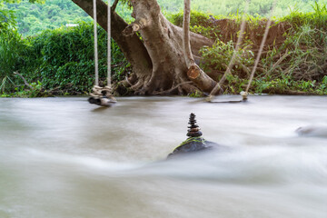 sort arrange stones or stack pebble stone tower or pyramid on rock and flow stream water for balance training and meditation concentrate with nature relax on summer holiday travel at river garden