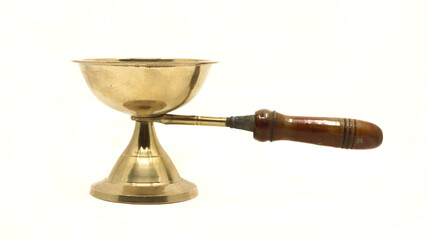 vintage golden brass diya oil lamp or vilakku with handle traditionally used for pooja rituals in temples of india isolated in a white background